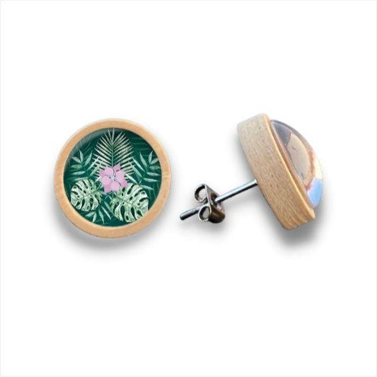 Ein Paar runde Holzohrstecker mit hölzernen Rändern, mit einem tropischen Blatt und rosa Blume Design unter einer klaren Cabochon-Glasscheibe. Ein Ohrring zeigt die Vorderseite, der andere zeigt die Seitenansicht und Metallstift.