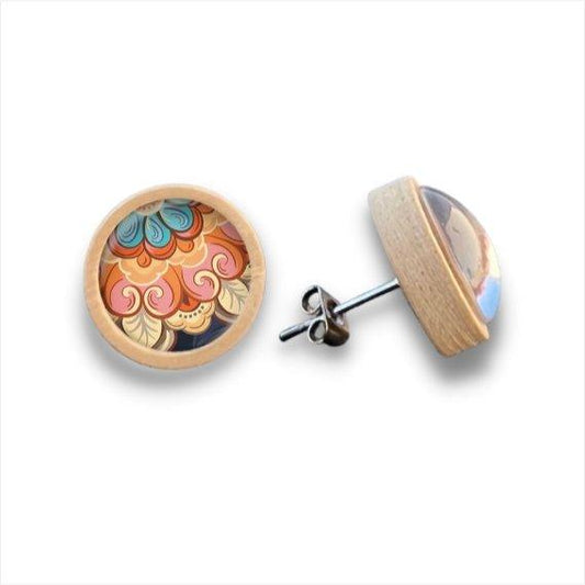 Ein Paar runder Holzohrstecker mit Birkenholzrahmen zeigt lebhafte abstrakte Muster in Orange, Rosa, Blau und Beige unter einer klaren Cabochonglaskuppel; ein Ohrring ist nach vorne gerichtet, der andere abgewinkelt.