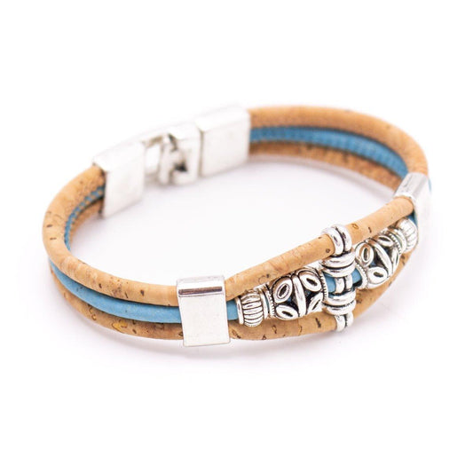 Ein umweltfreundliches Holzstollen Kork-Armband mit zwei tanfarbenen und einem blauen Band, verziert mit edlen Silberperlen und rechteckigem nickelfreiem Edelstahl-Verschluss.