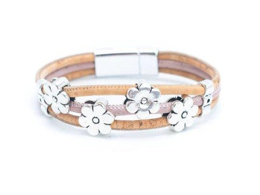 Das Armband mit Holznieten besteht aus hellbraunen und rosafarbenen Lederbändern, fünf silbernen Blumenanhängern und einem nickelfreien Magnetverschluss aus Edelstahl - ein umweltfreundliches Accessoire, das sowohl stilvoll als auch sanft zur Haut ist.