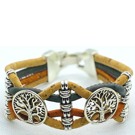 Das Holzarmband ist handgefertigt mit braunen und schwarzen Lederbändern, zwei silbernen Lebensbaum-Anhängern und nickelfreien Edelstahlperlen auf weißem Hintergrund.