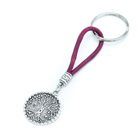 Ein silberner runder Schlüsselanhänger mit einem Lebensbaum-Motiv aus Holznägeln, befestigt an einem silbernen Ring durch eine Schlaufe aus dunkelrotem Stoff - ein umweltfreundliches Accessoire für Ihre Schlüssel.