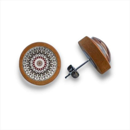 Ein Paar runder Holzohrstecker mit Kanten aus Birkenholz und geometrischen Mustern im Mandala-Stil in Schwarz, Weiß und Rot. Einer steht aufrecht, der andere zeigt seine Metallunterlage unter der Cabochon-Oberfläche.