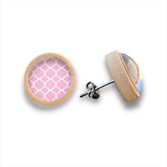 Ein Paar runde Ohrstecker aus Holz mit einem hellen Birkenholzrand und einem rosafarbenen Hintergrund mit weißem Vierblättermuster, gekrönt von einem Cabochon aus klarem Glas für einen eleganten Abschluss. Marke: Holz Ohrstecker.
