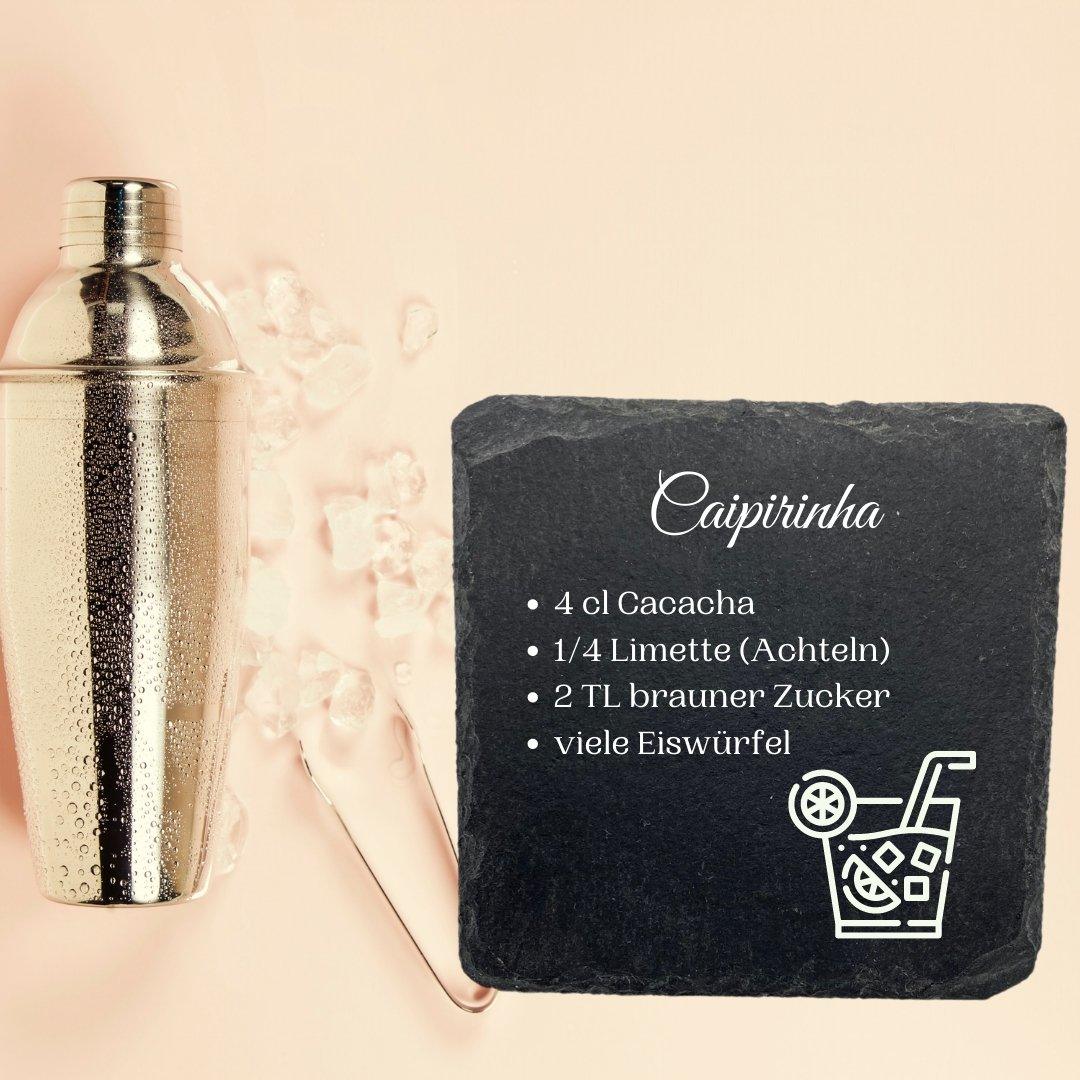 Ein hölzerner Cocktail-Shaker mit Eiswürfeln steht neben einem Schieferuntersetzer mit einem deutschen Caipirinha-Rezept, komplett mit Zutaten und einem Getränkesymbol - ideal zum Sammeln Ihrer Lieblings-Cocktail-Rezepte.