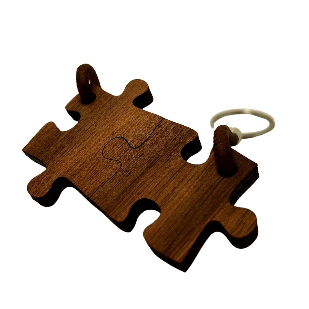Schlüsselanhänger Puzzle aus Holz: dunkelbraune Puzzleteile ineinandergesteckt.