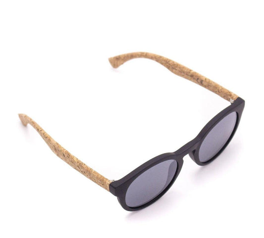 Die runde Kork-Sonnenbrille mit Holzstollen hat einen schwarzen Rahmen, dunkle Gläser und hellbraune Bügel mit Korkmuster, die aus nachhaltigen Materialien bestehen. Auf weißem Hintergrund abgebildet. Bietet UV400-Schutz für zuverlässige Augensicherheit.