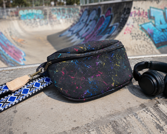 Schwarz-bunte Gürteltasche aus Kork mit gemustertem Gurt im Skatepark
